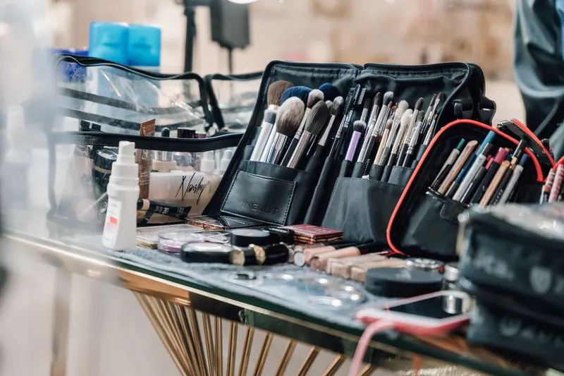 Professional makeup brushes and tools laid out in open cases on a table