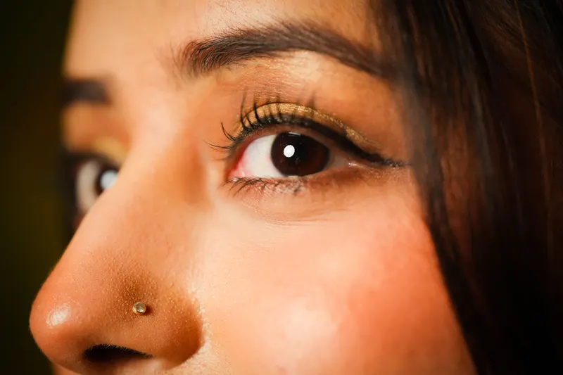 Side view of a brown eye with warm bronze eyeshadow and defined lashes