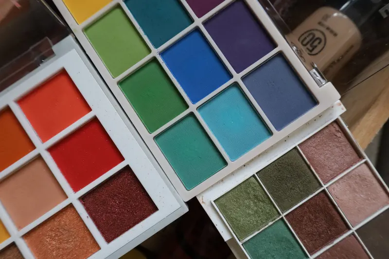 Open eyeshadow palettes in warm reds, blues and greens