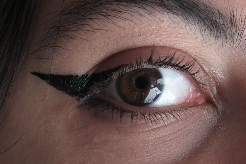 A close-up of a brown eye with a sharp black winged liner and natural lashes.