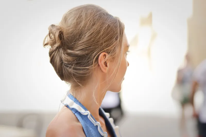 Young woman in a blue dress with her hair in a soft textured updo