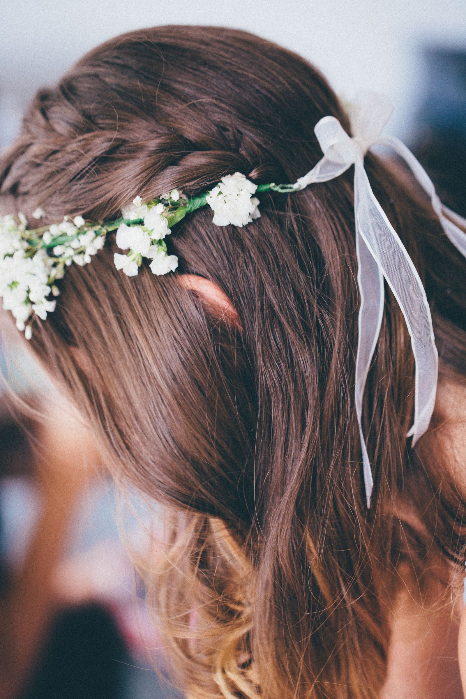 A bride wears a halo braid, a romantic option among braided wedding hairstyles for outdoor ceremonies.