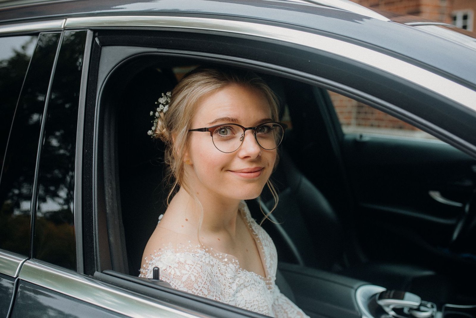 A joyful bride wearing her eyeglasses with her bridal makeup on her wedding day.