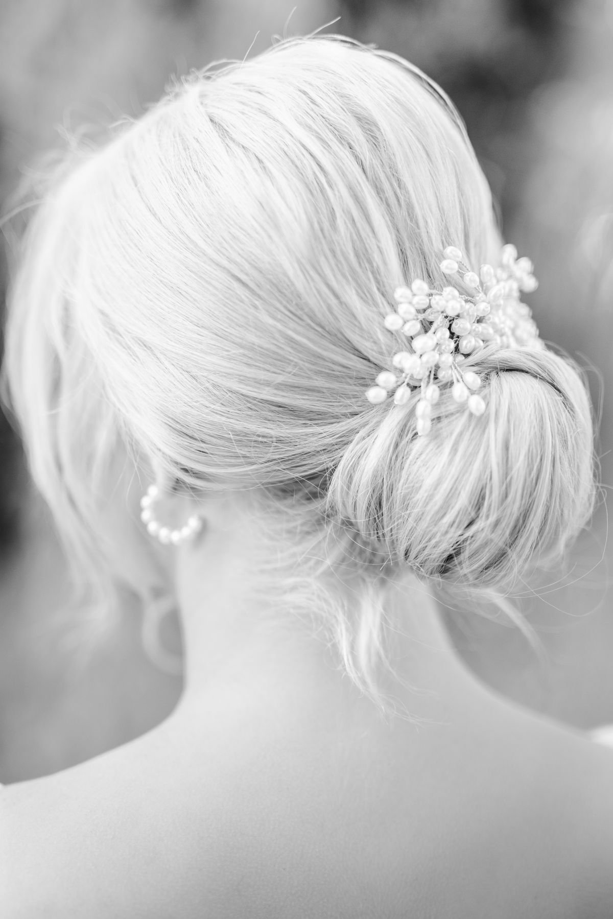 A bridesmaid updo hairstyle featuring a soft, twisted low bun for a wedding.