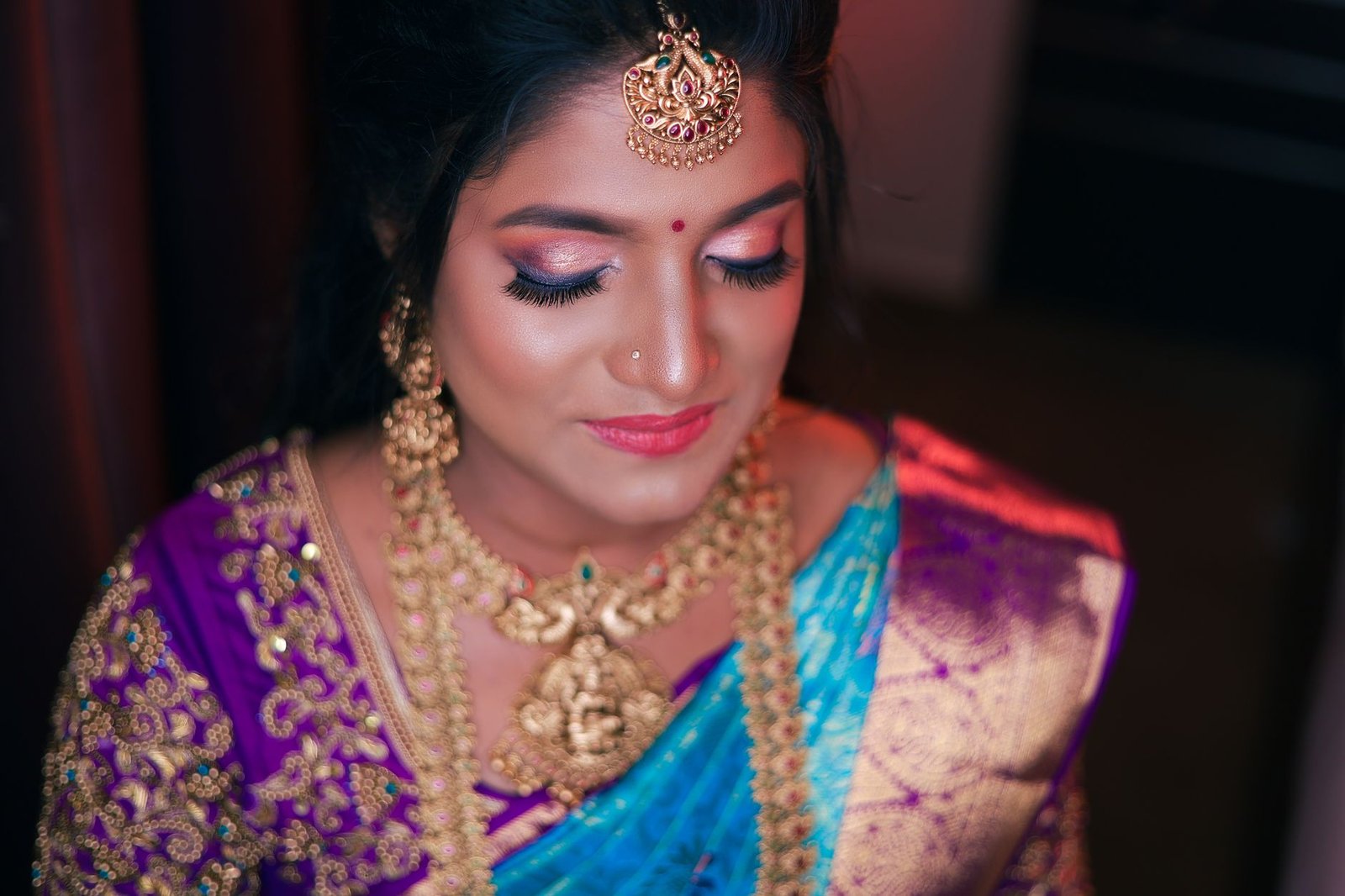 A finished South Asian wedding makeup look pairs with gold bridal jewelry.