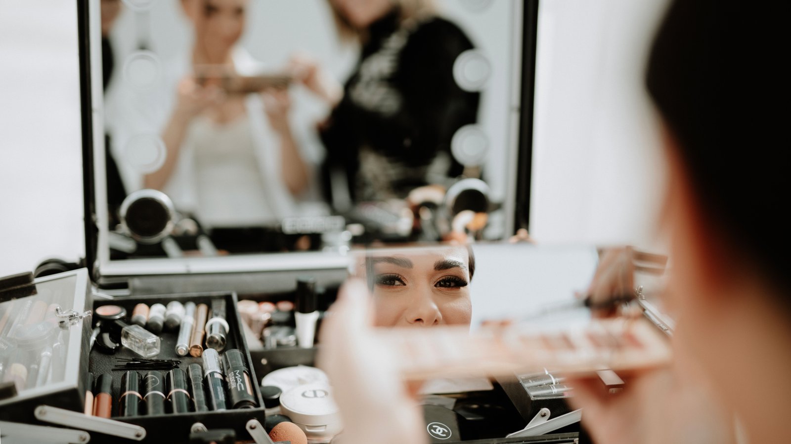 A makeup artist completes a bridal look, reflecting the kind of detailed service that affects overall wedding makeup cost.