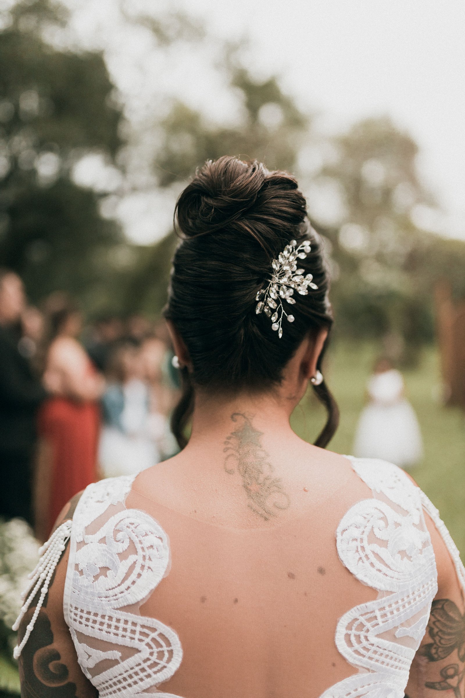 A bride shows off her full wedding hairstyle from behind, highlighting the finished shape and detail.