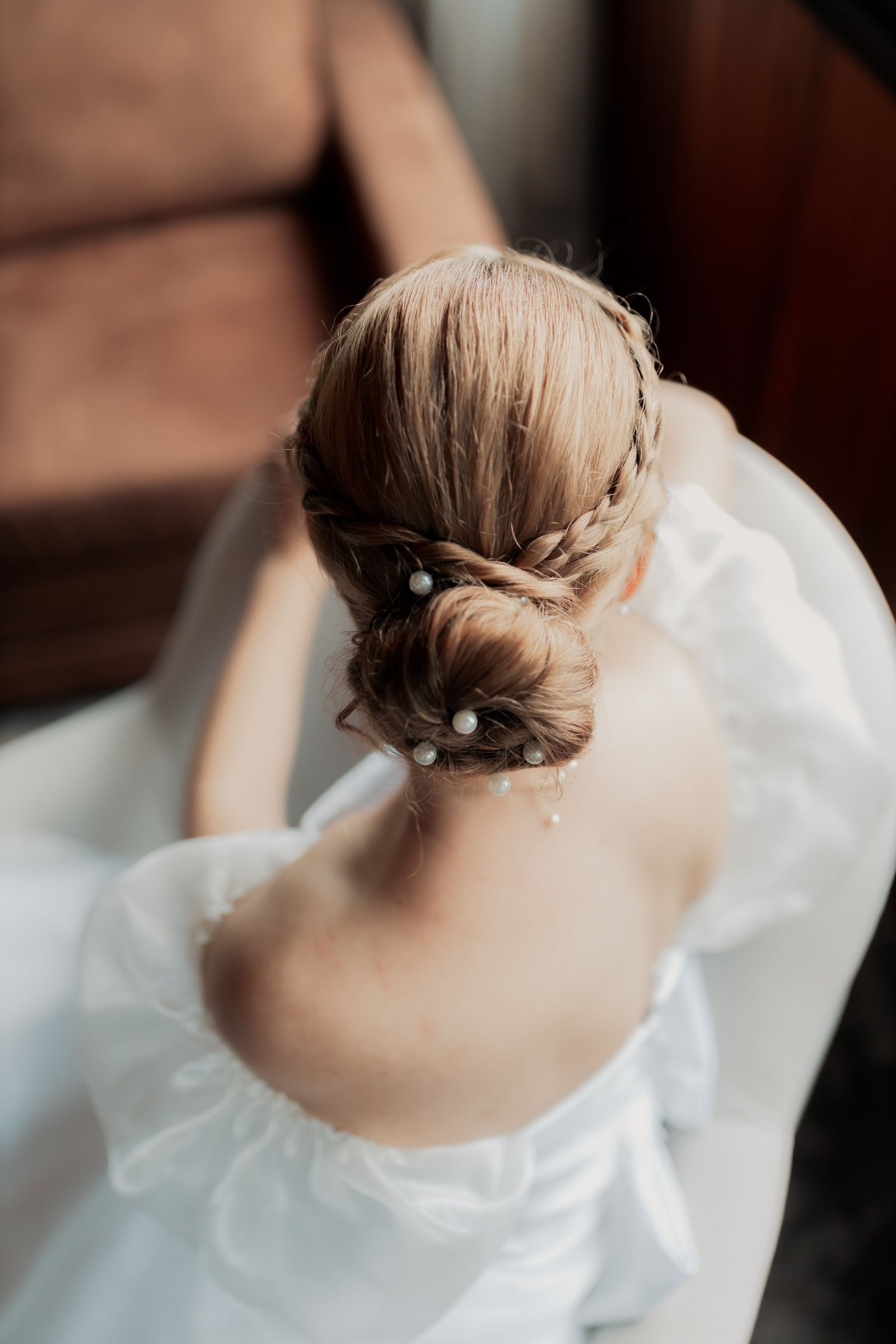 A bridal updo with pearl details shows how a messy bun wedding hairstyle can incorporate elegant accents.