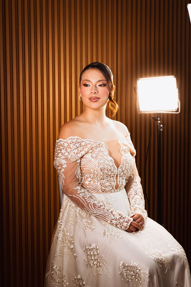 A bride with elegant, coordinated bridal hair and makeup in a lace gown.