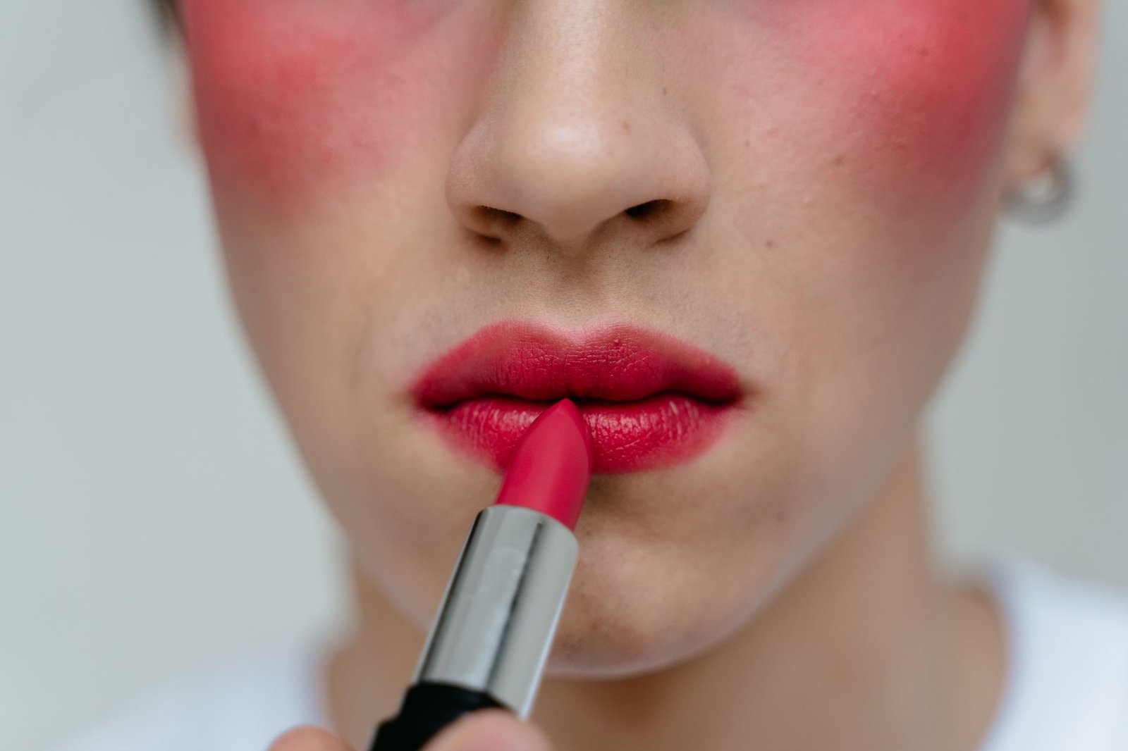 A makeup artist blends cream blush for a subtle makeup look.