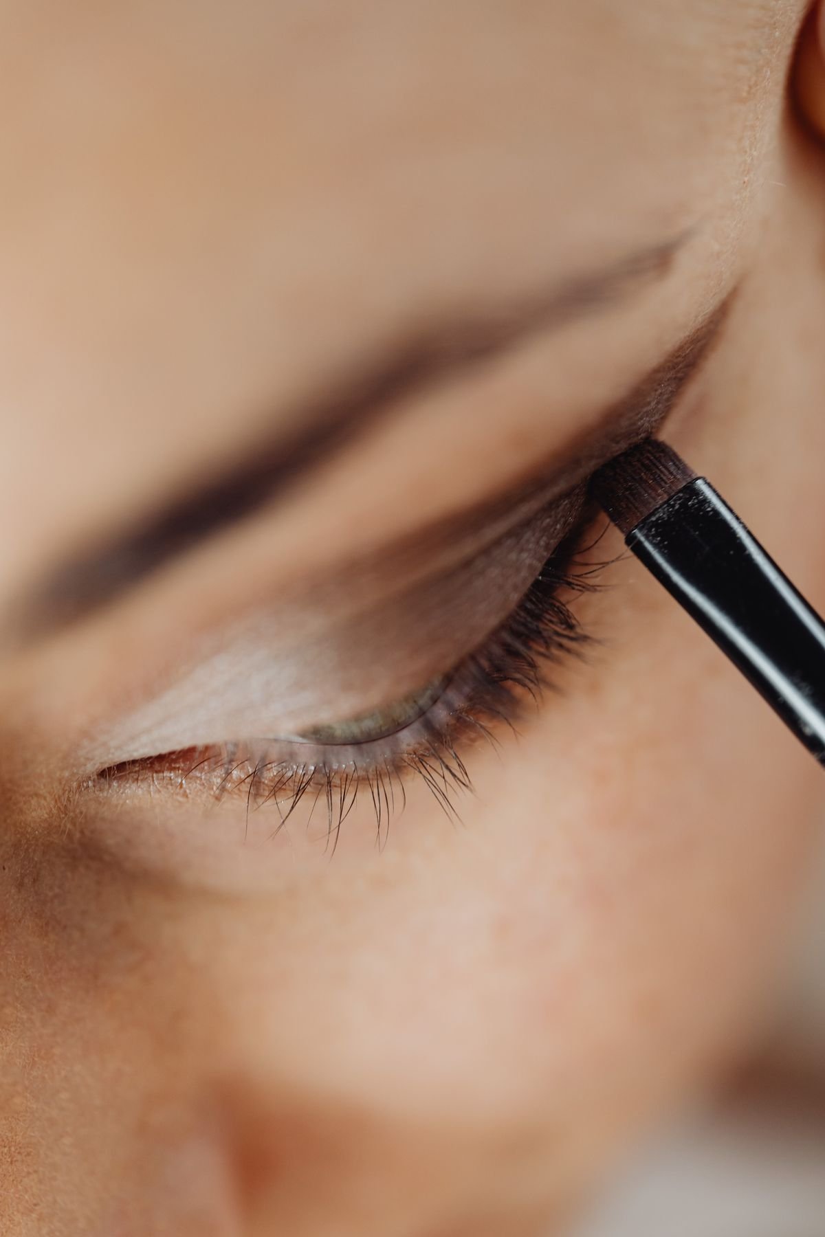 A makeup artist demonstrating eyeshadow blending technique for beginners.