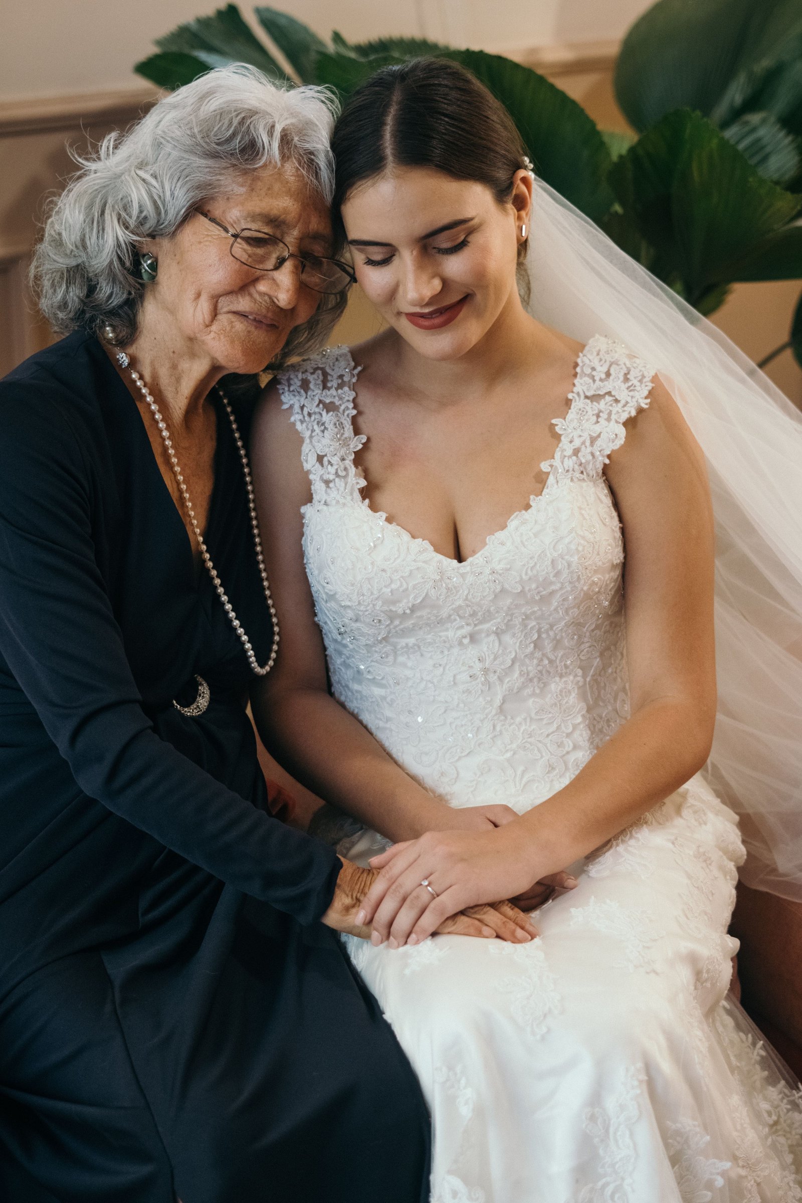 A mother with soft, elegant gray hair styled for the wedding day embraces the bride, an example of a graceful mother of the groom hairstyle.