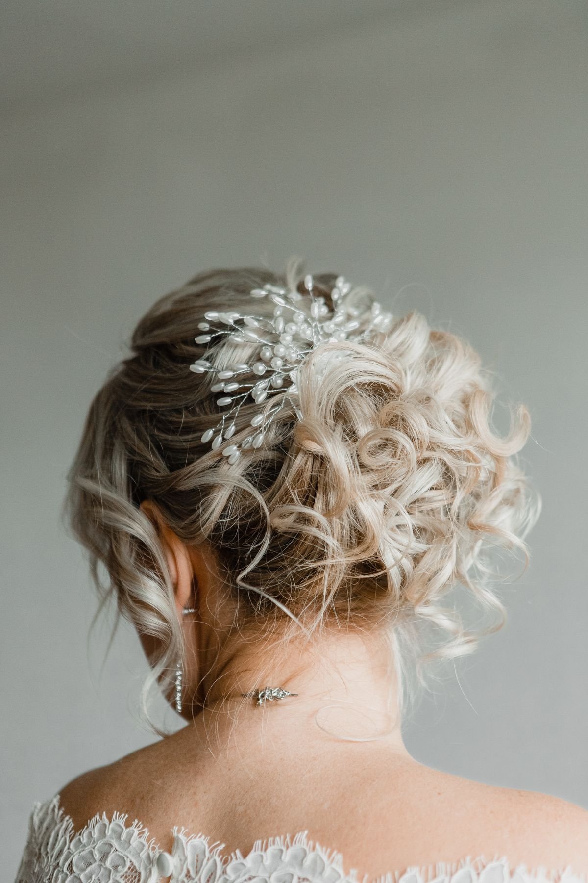 An elegant mother of the bride updo styled with soft, textured pieces for a formal wedding.