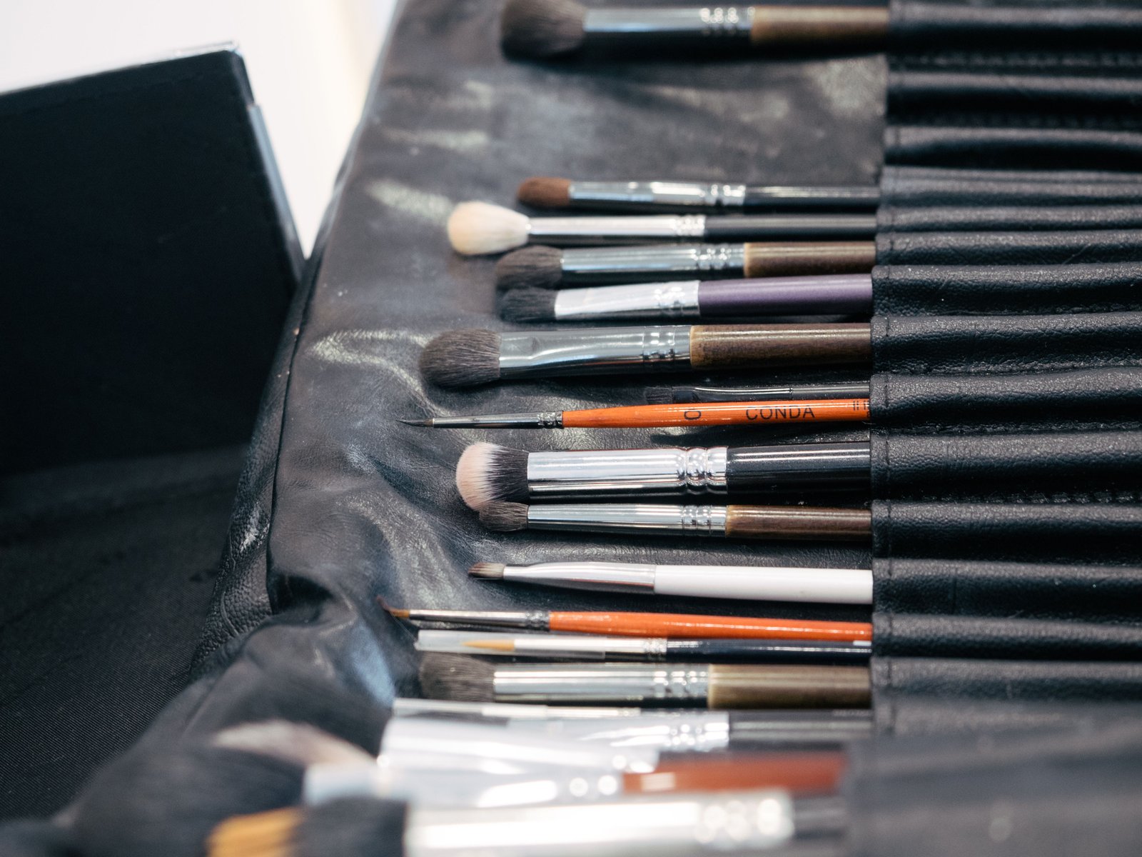 Collection of professional makeup brushes neatly arranged in a kit case