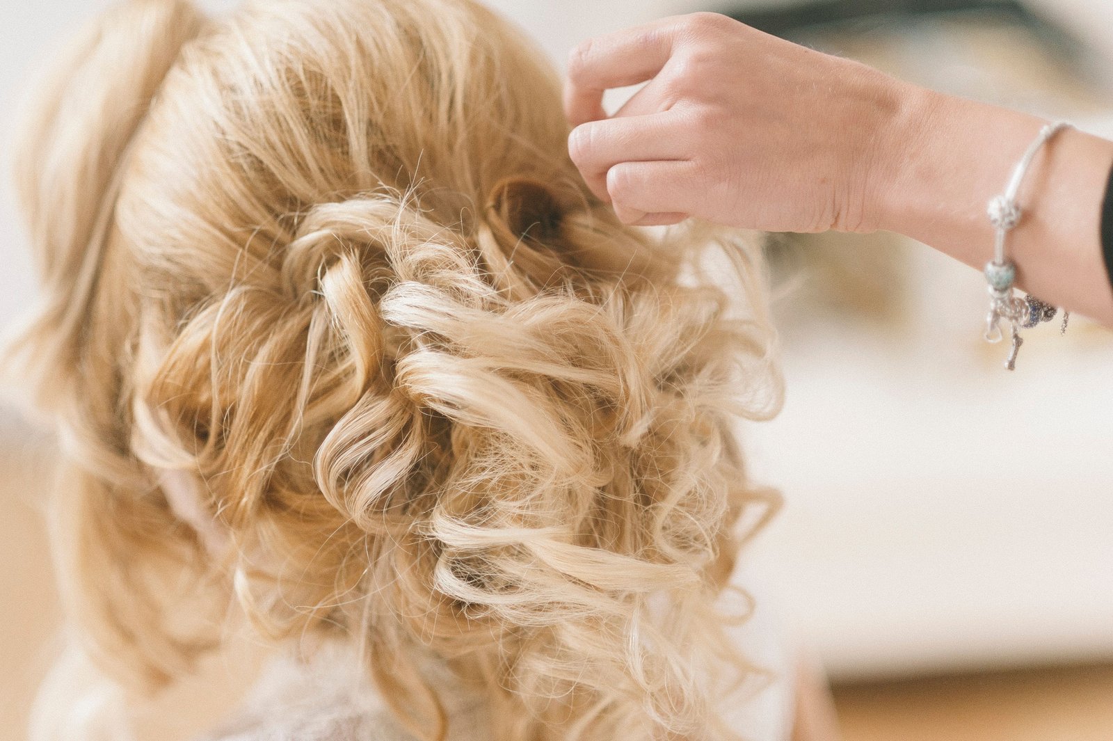 Hairstylist finishing a smooth bridal updo