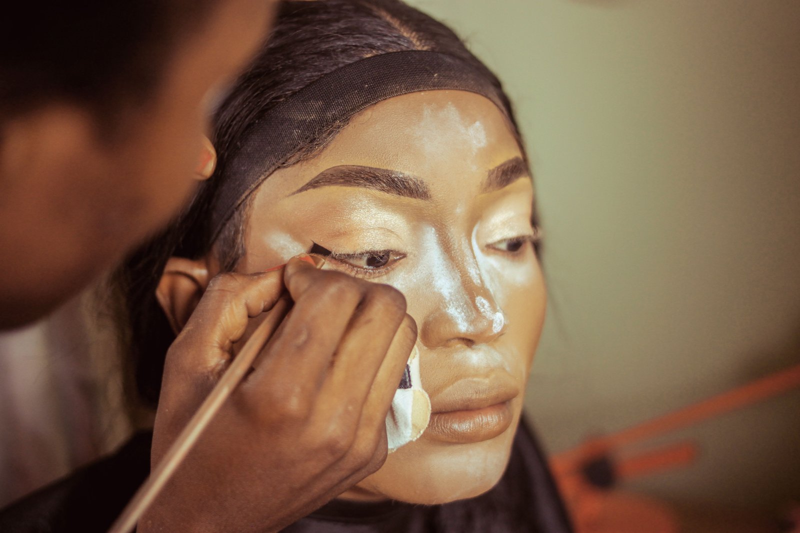 Makeup artist carefully setting foundation with translucent powder