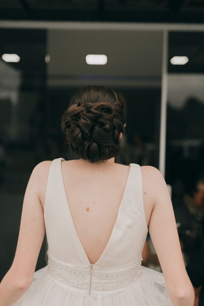 Bride with a glossy, smooth updo finished with a touch of Olaplex oil