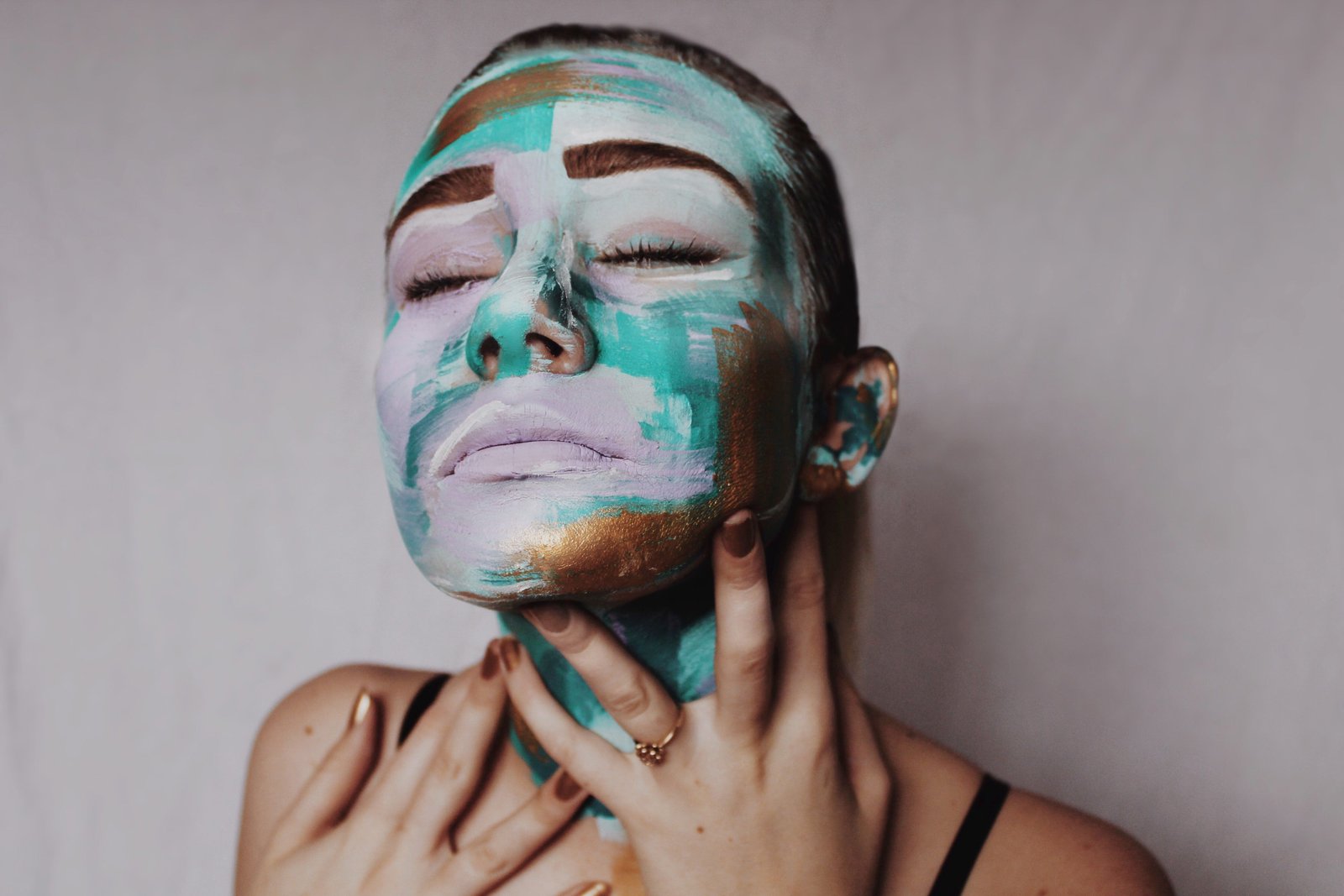 Close-up portrait of vibrant, abstract face paint designed for a styled shoot