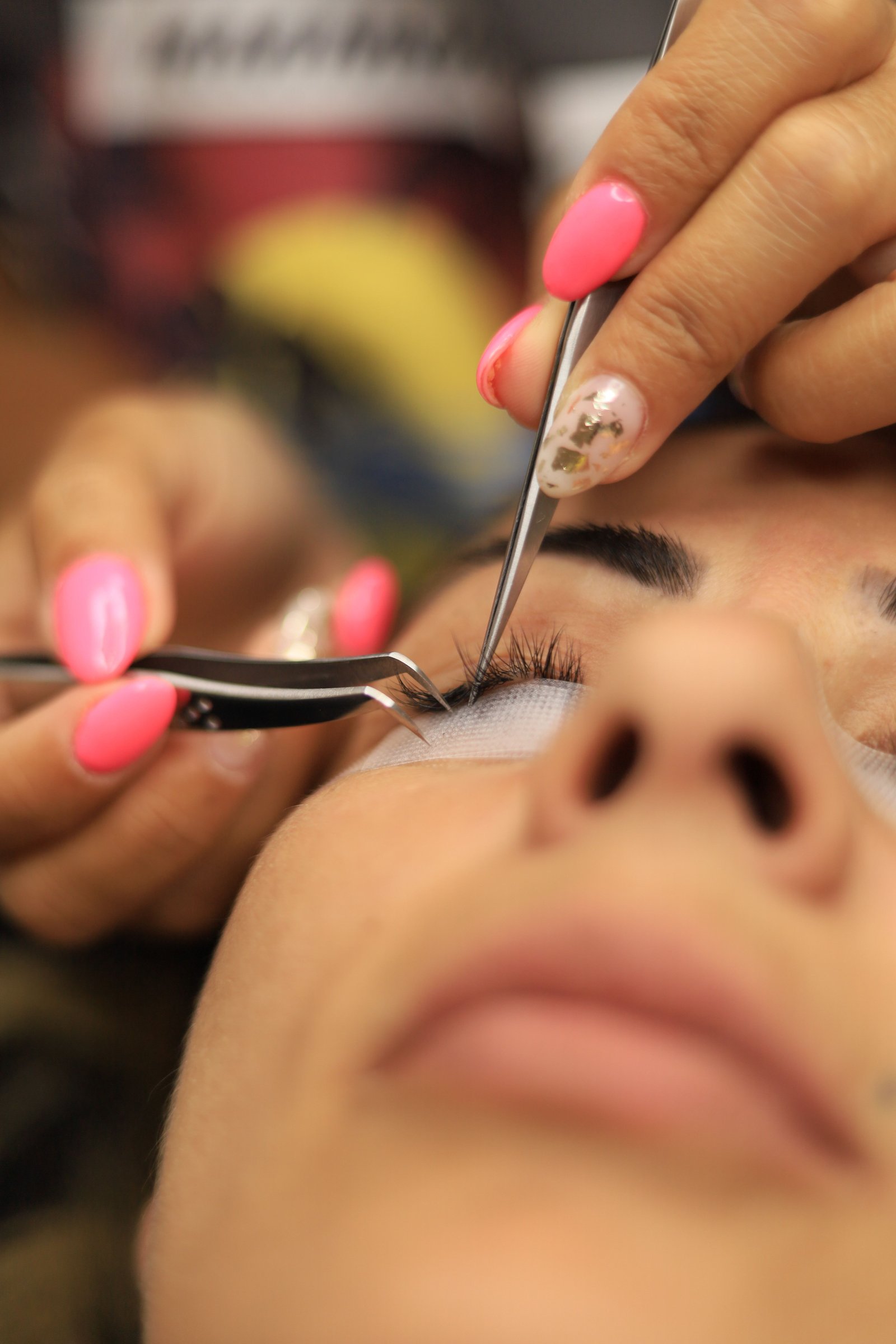 Close-up of a wispy false lash being applied to the natural lash line