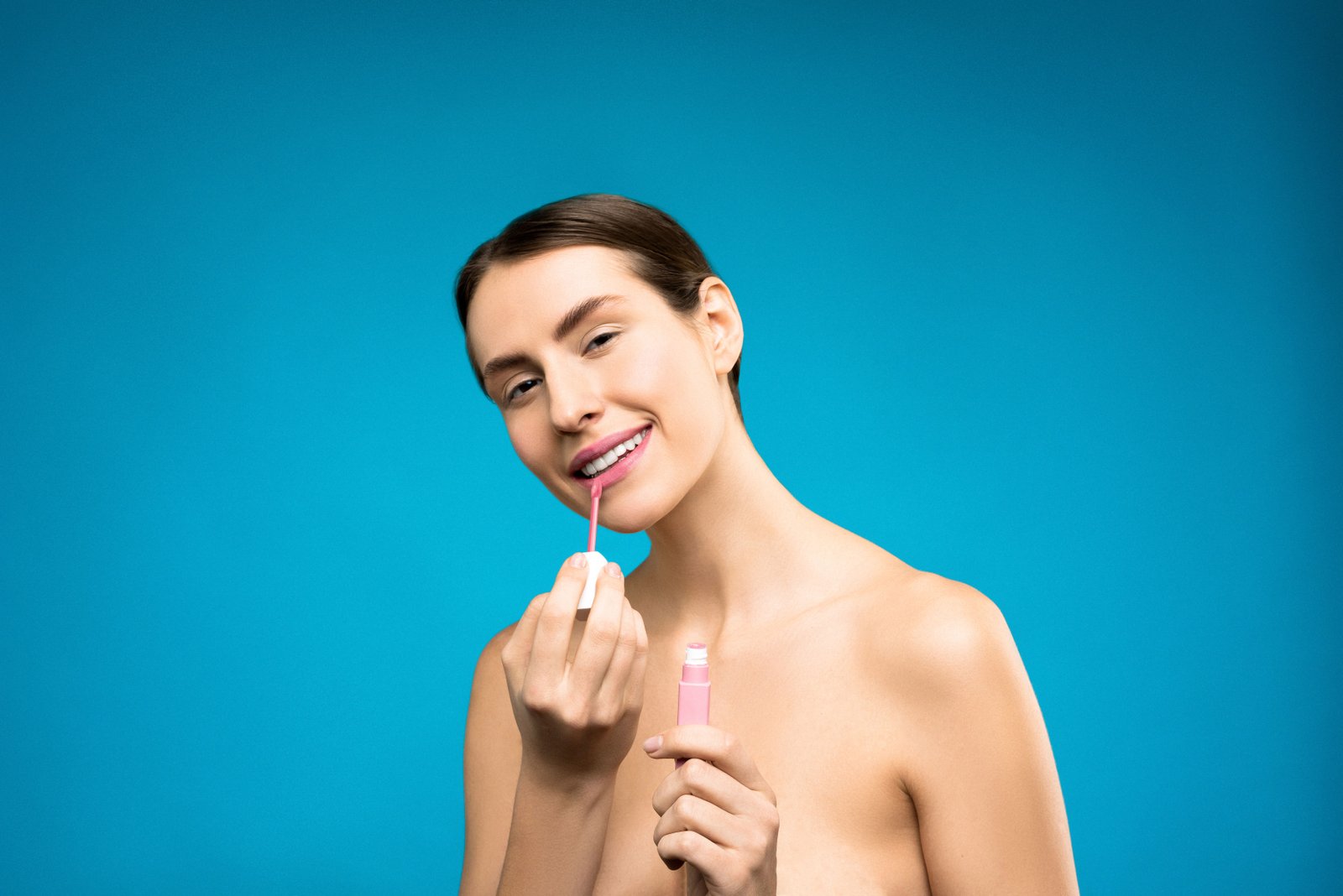 Bride applying a long-wearing nude-pink lipstick shade