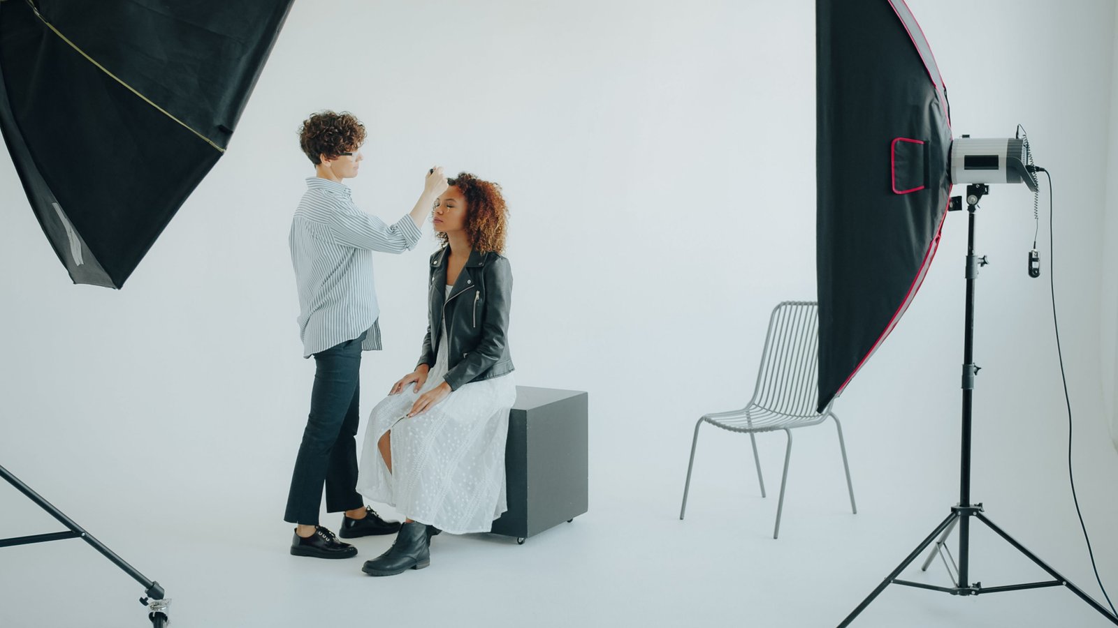 Makeup artist preparing a model's face paint look before a photography session