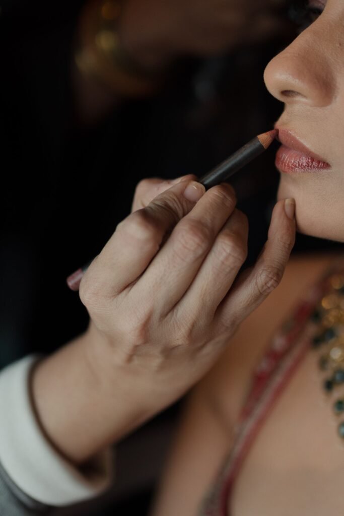Makeup artist applying Pillow Talk lip liner along a bride's natural lip line