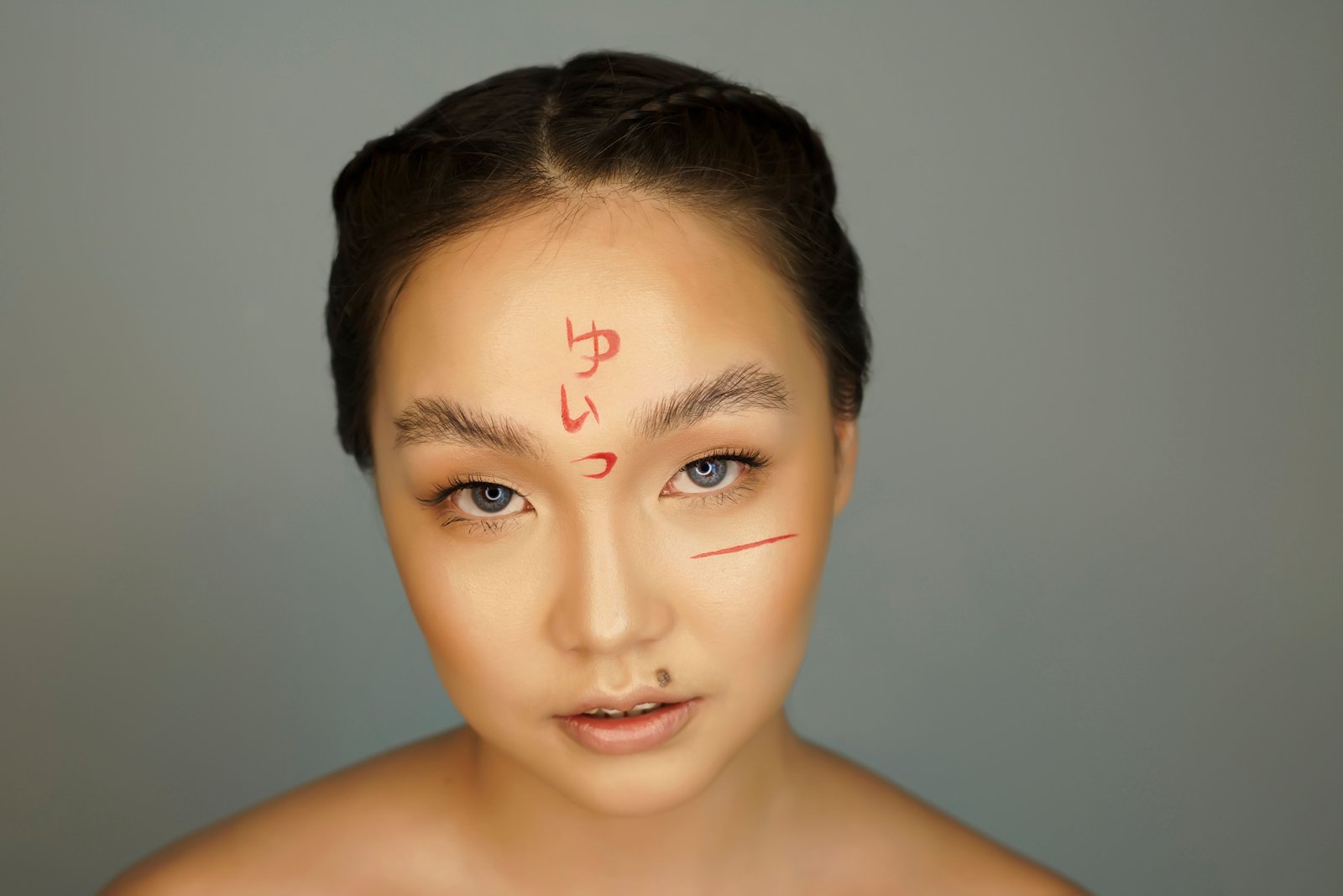 Close-up portrait of bold, creative face paint applied in a studio setting