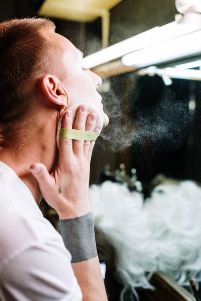 Performer pressing powder over stage makeup, the way Mehron foundation greasepaint is set before a show