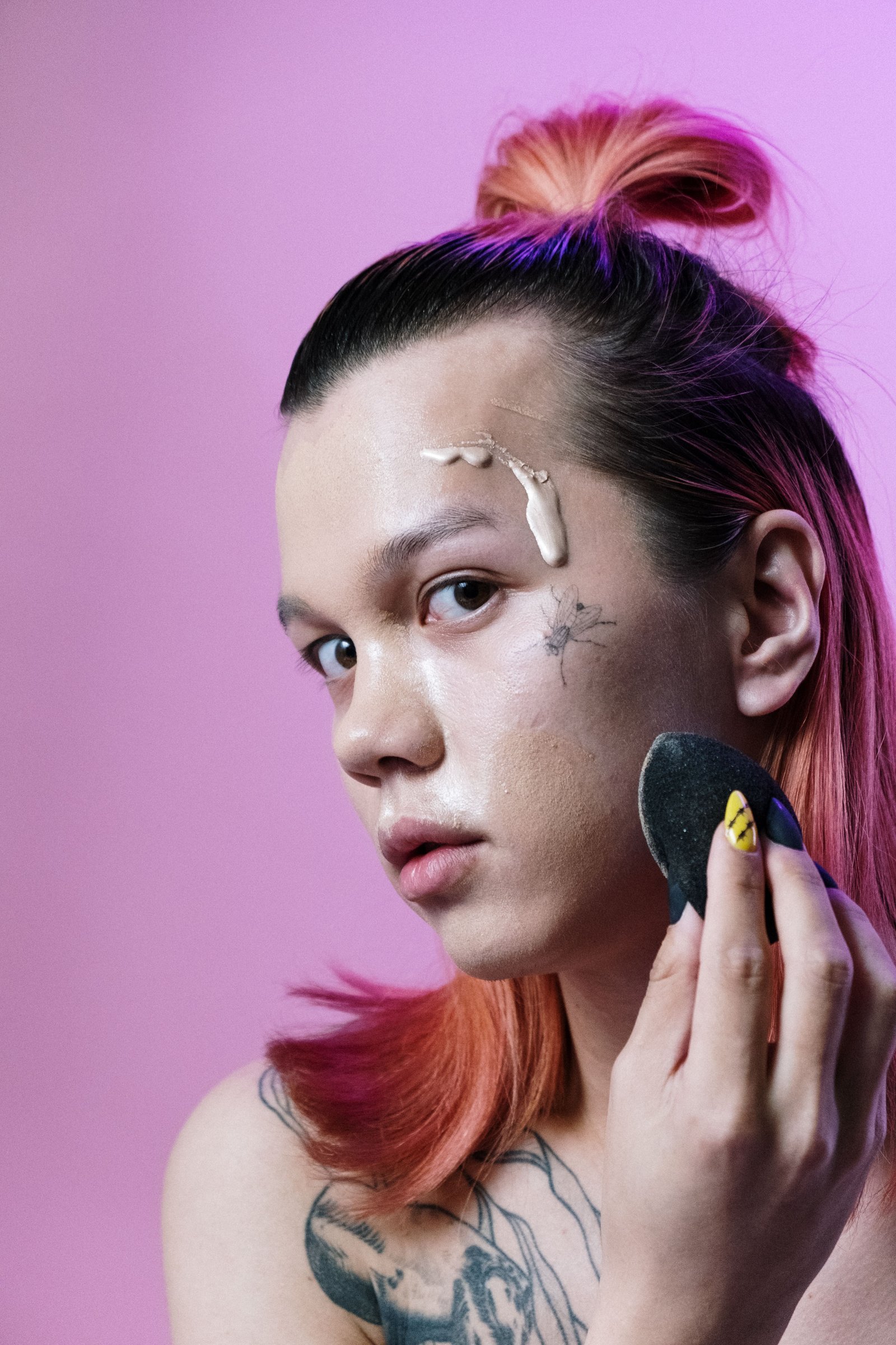 Applying cream contour with a makeup sponge for a blended finish