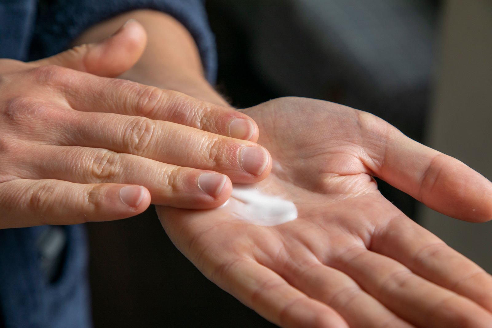Detailed view of hands applying hair cream