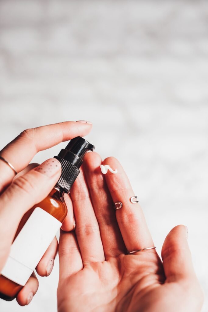 Close up of hands with a pump bottle, a reminder to check ingredients before deciding if a setting spray is good for your skin