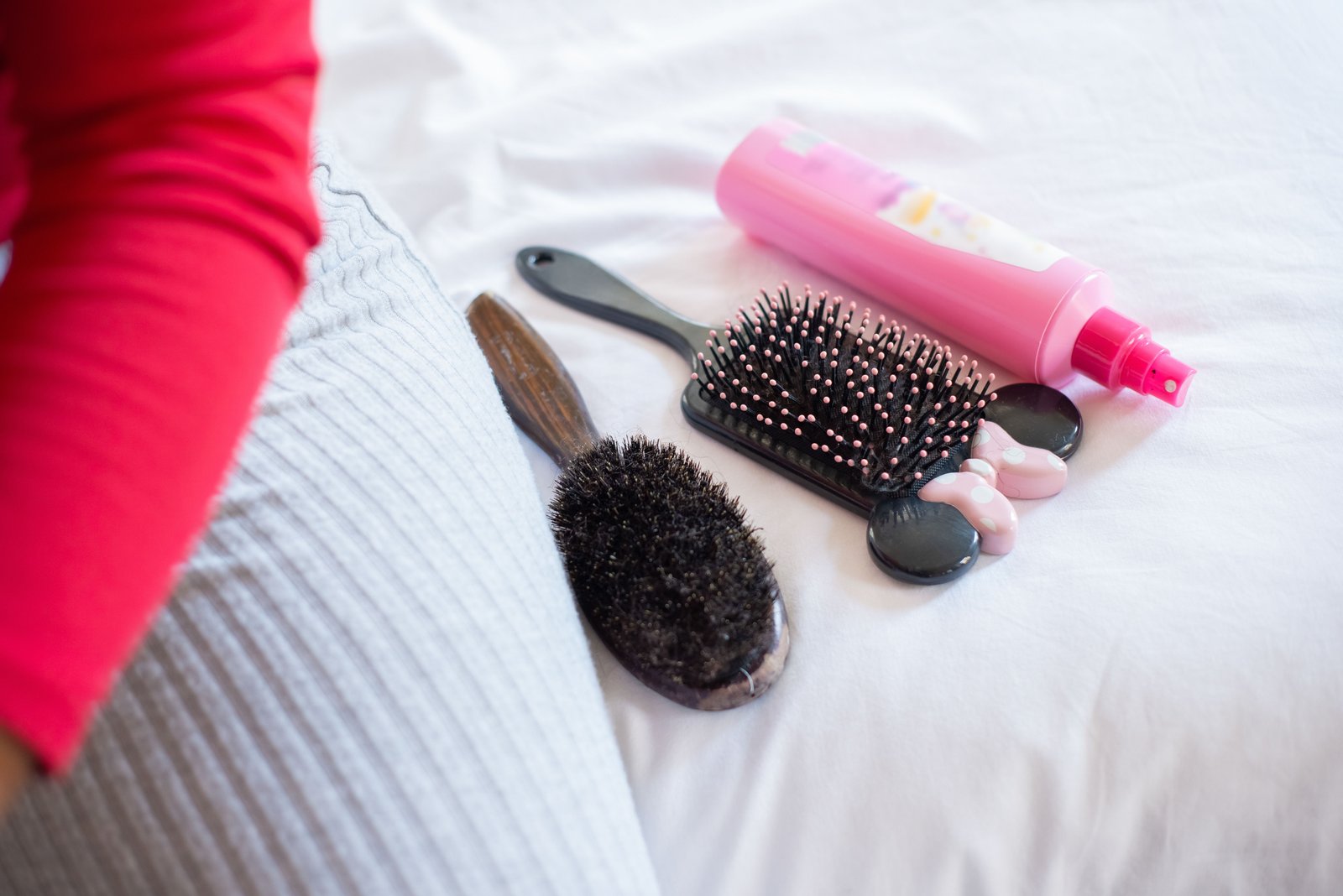 Hair styling brushes and finishing products laid out for an updo application