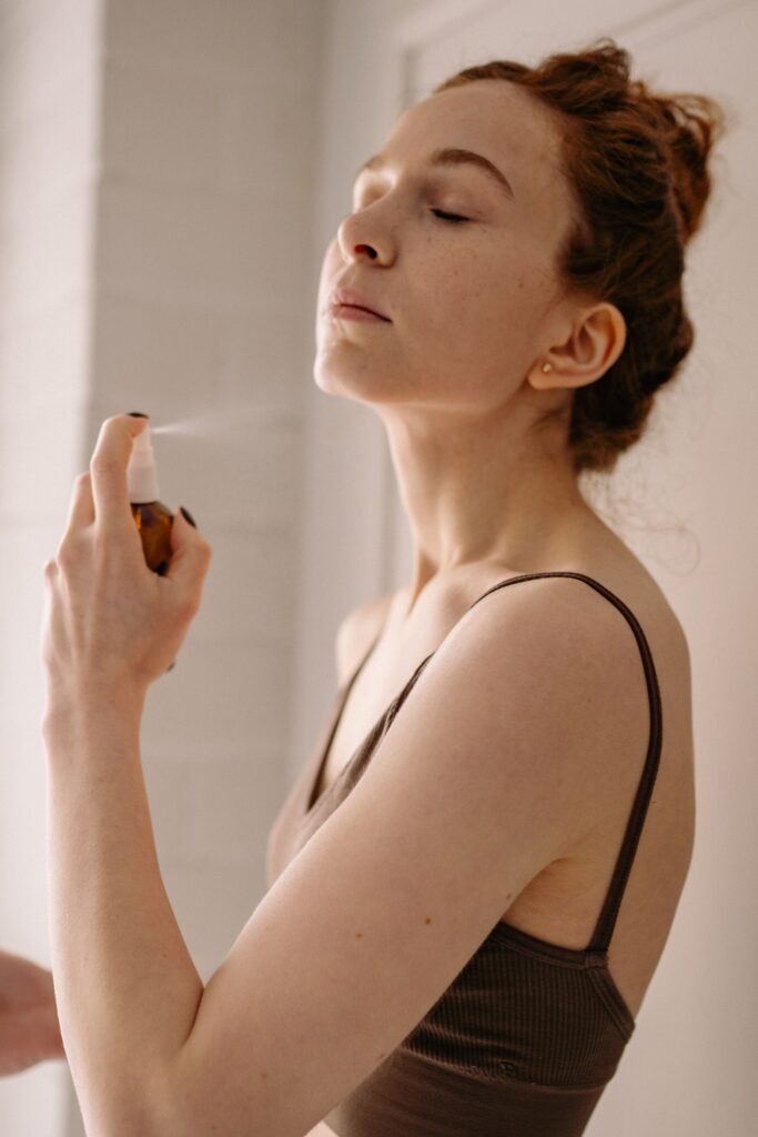 Woman misting the best setting spray for makeup over her finished look
