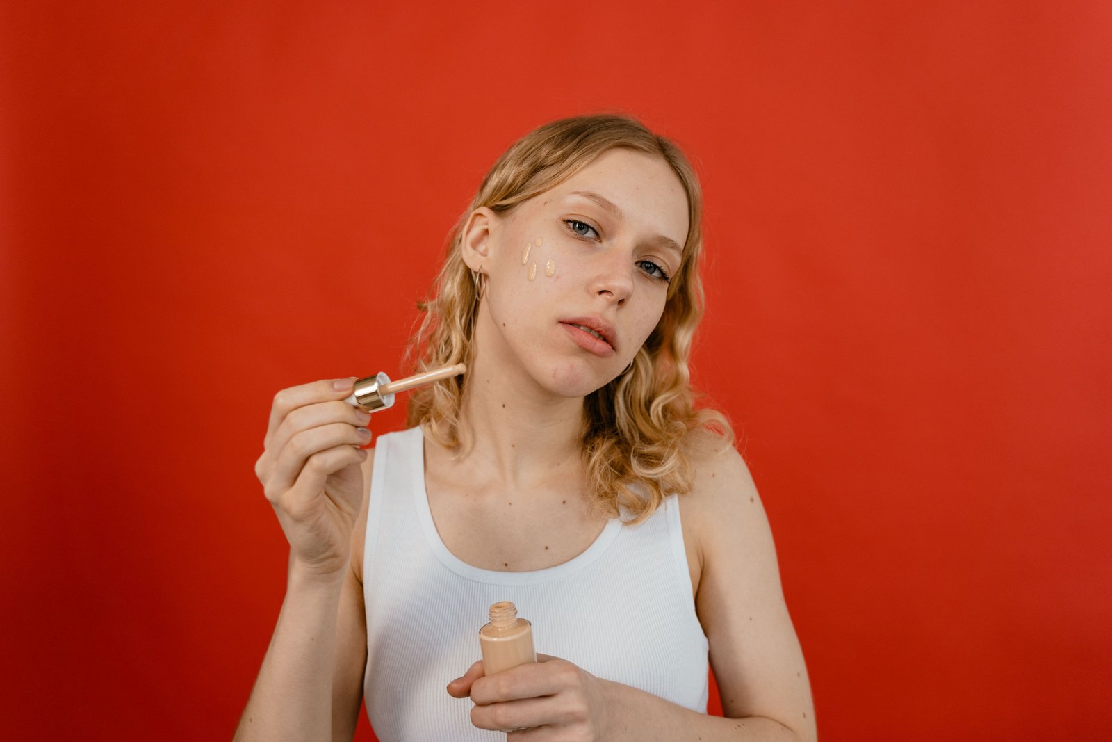 Woman applying foundation to her face