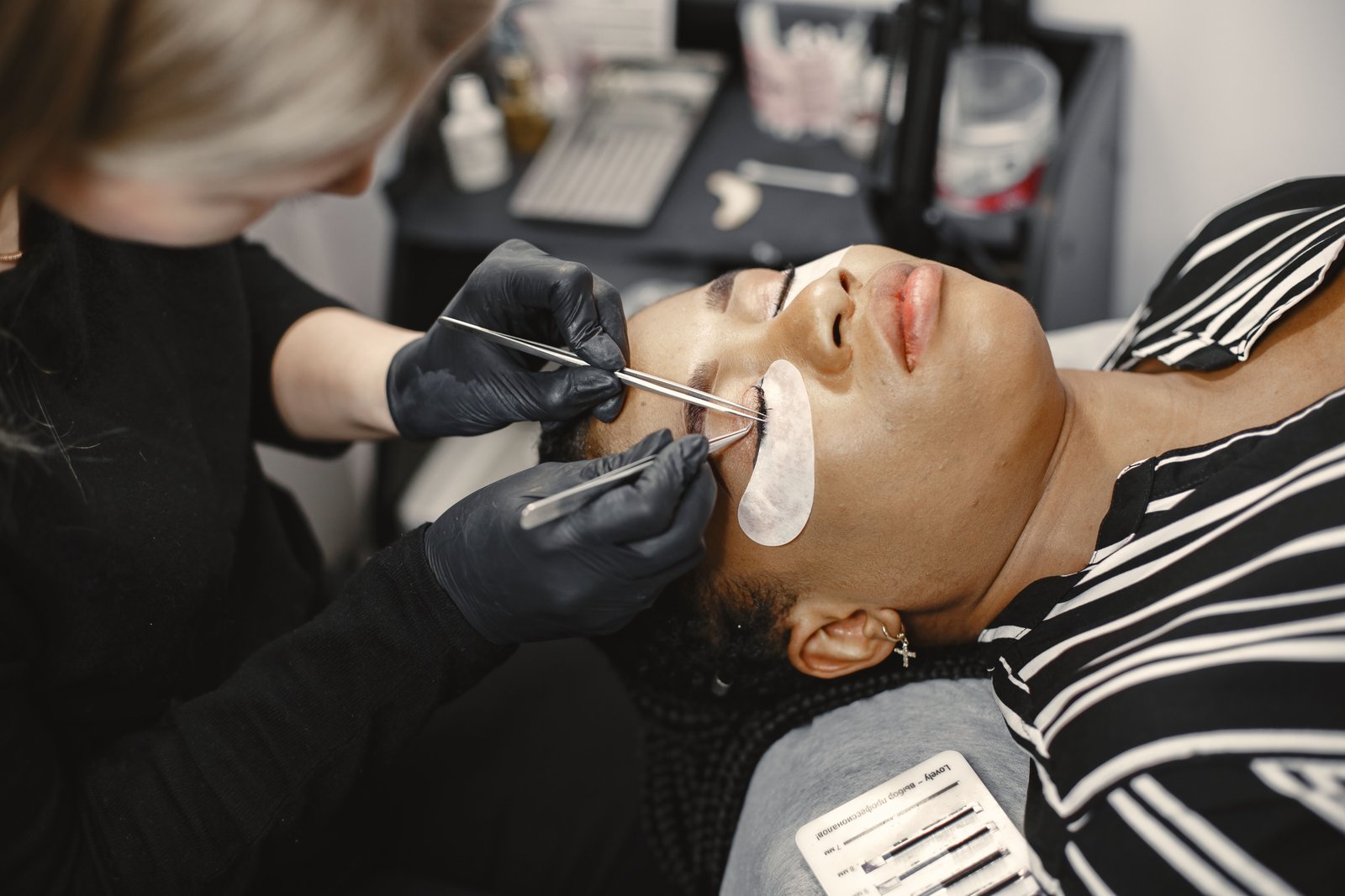 Lash technician applying extensions using premium lash material in a studio
