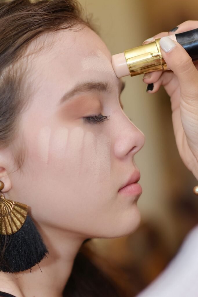 Makeup artist applying corrector and concealer under a client's eyes, the step where Charlotte Tilbury Magic Vanish is used