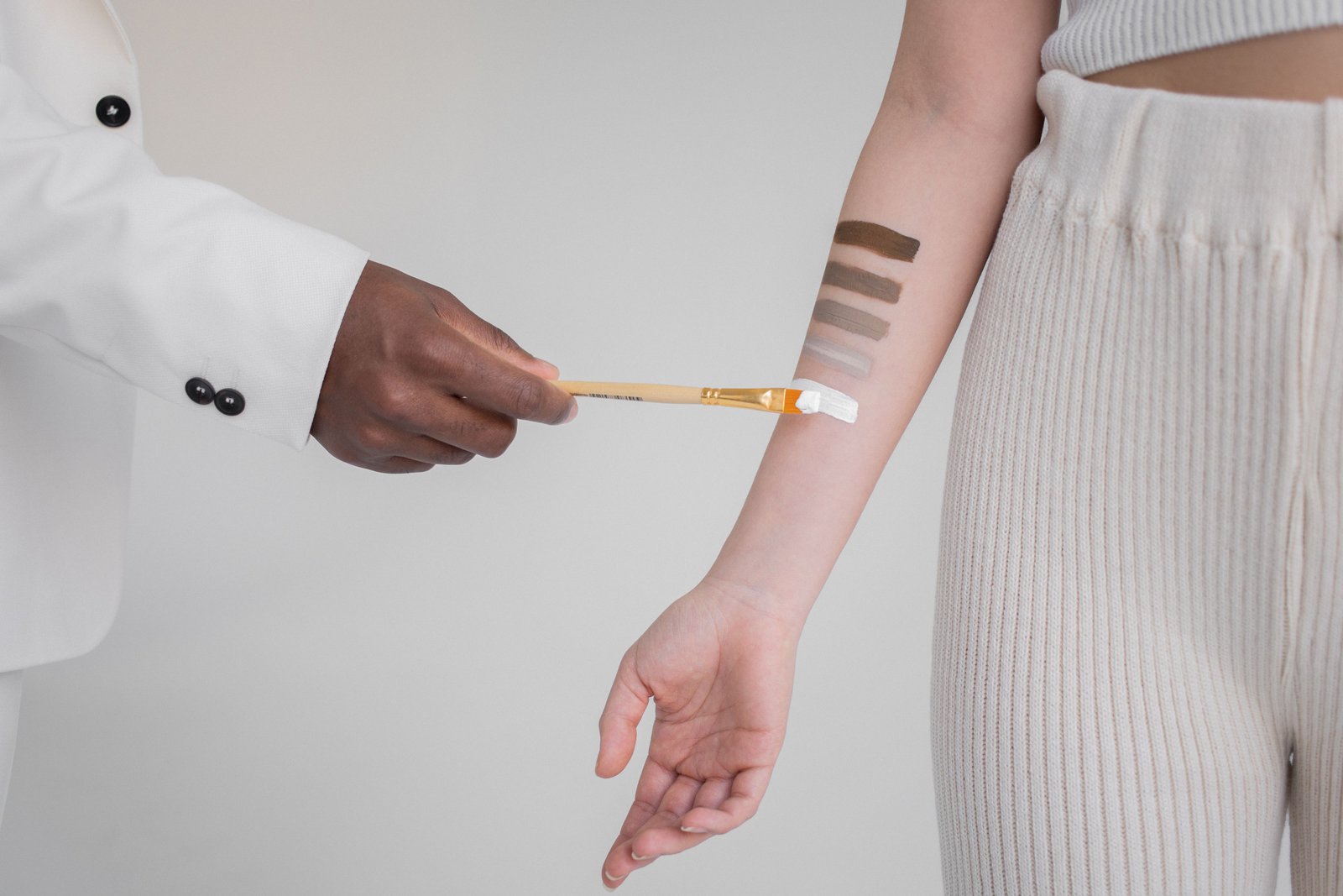 Makeup artist testing multiple foundation shades against a client's skin tone