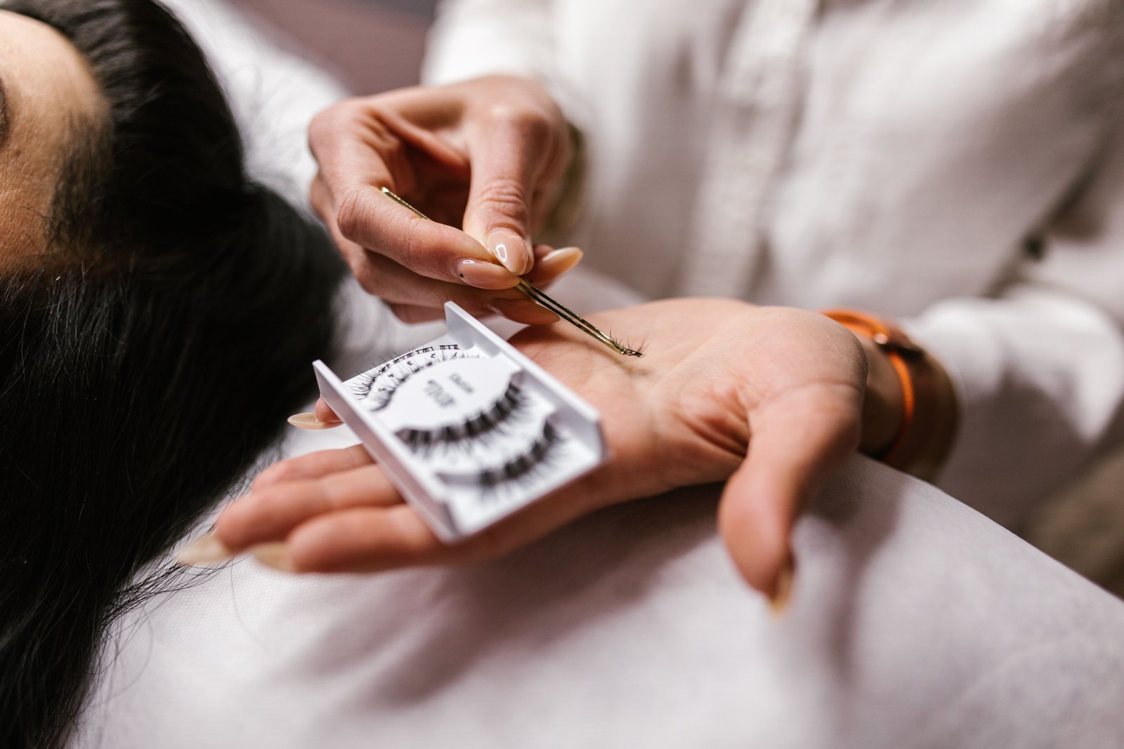 Close-up of an eyelash extension application using tweezers