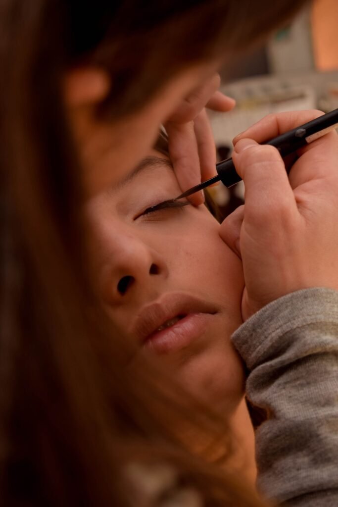 Makeup artist applying liquid liner along the lash line, the first step for Kiss magnetic lashes