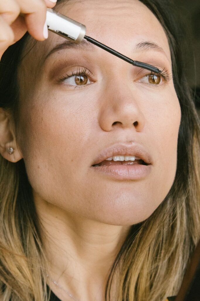 Close up of a woman applying Lash Paradise Mystic Black style volumizing mascara