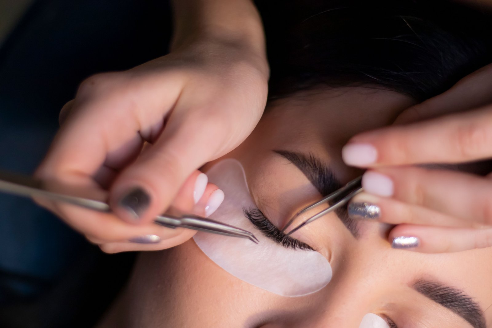 Beautician carefully applying eyelash extensions during a client appointment