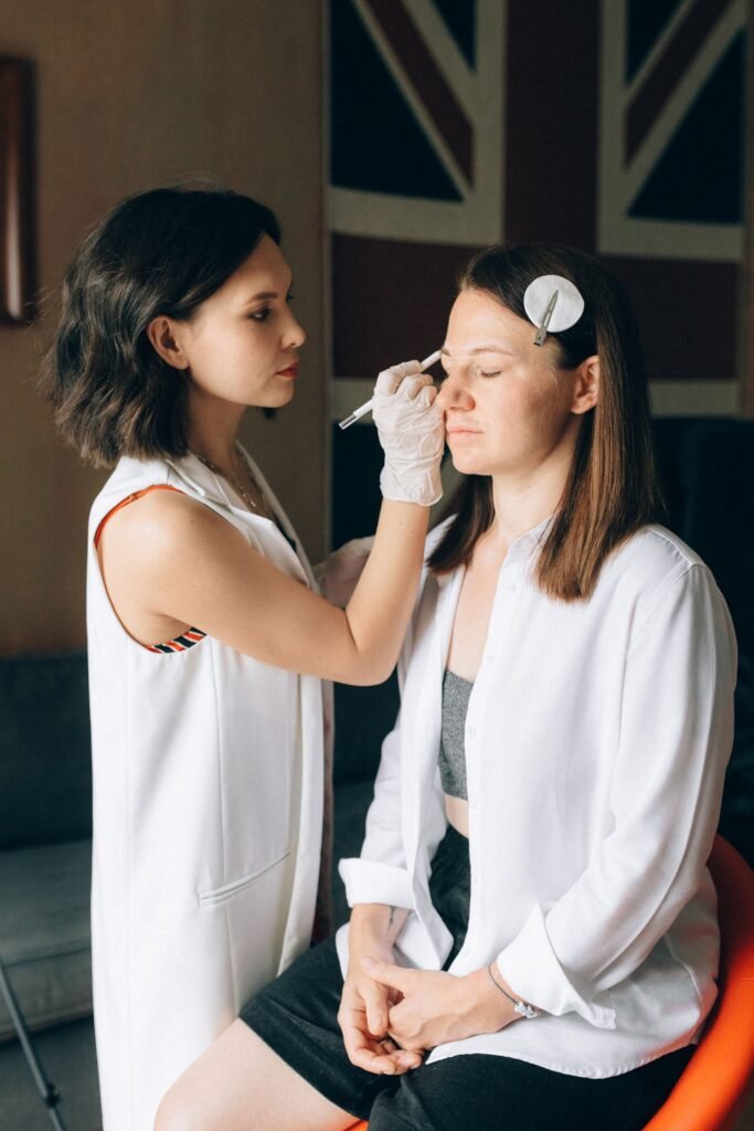 Makeup artist applying Bobbi Brown Vitamin Enriched Face Base style primer to a bride's cheek