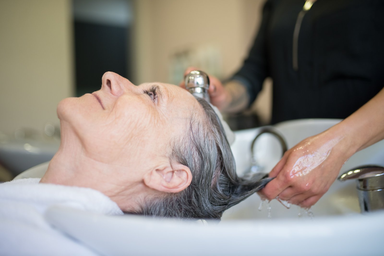 Client enjoying a relaxing hair wash session in a professional salon